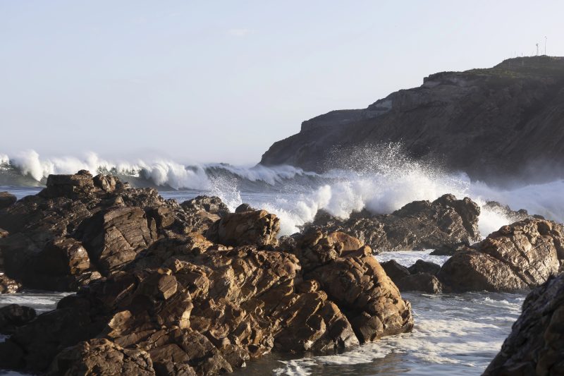 Brandung an dunklen Felsen unterhalb von Cape St Blaize